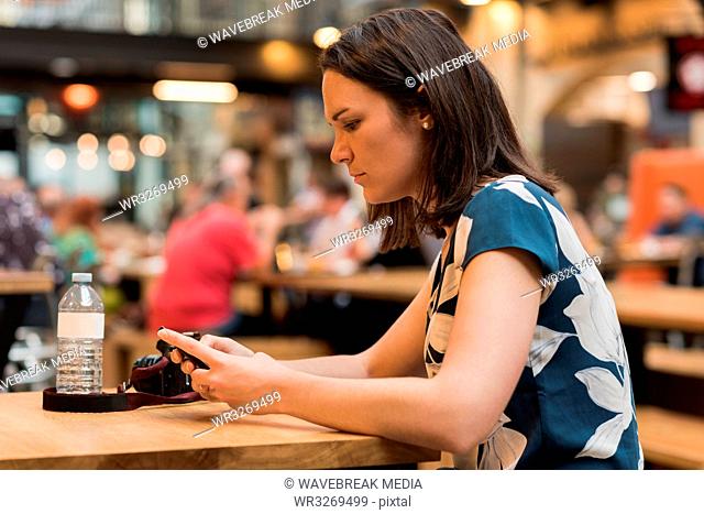 Woman using mobile phone in restaurant