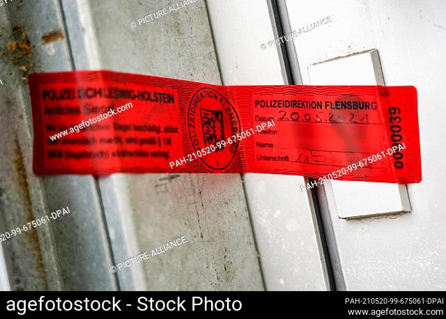 20 May 2021, Schleswig-Holstein, Kiel: A seal of the Flensburg police department is stuck to the entrance of a house. A body has been found in the house