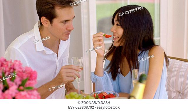 Couple sipping wine and eating fruit