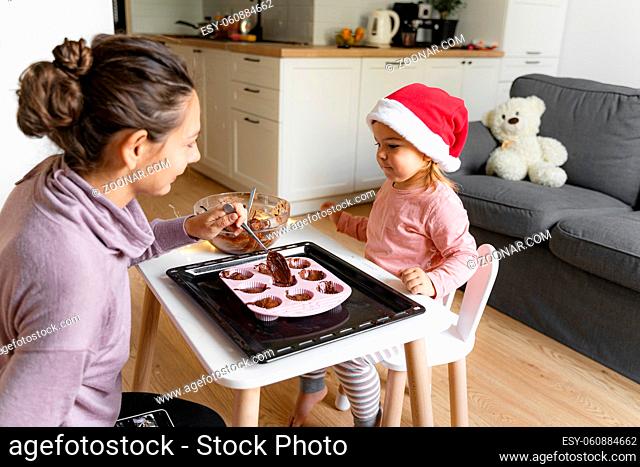 Mother with child preparing holiday cookies at home. Happy family time together. High quality photo