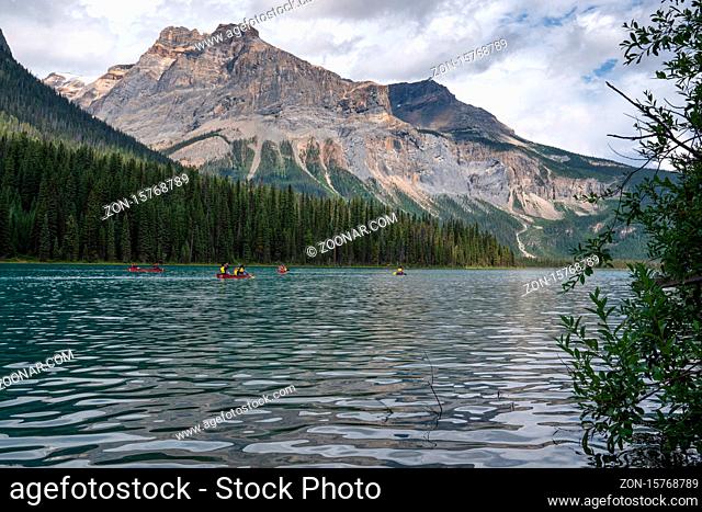 FIELD, CANADA - AUGUST 14, 2019: Tourists are canoeing on Emerald lake in front of the magnificent backdrop of the Rocky Mountains on August 14