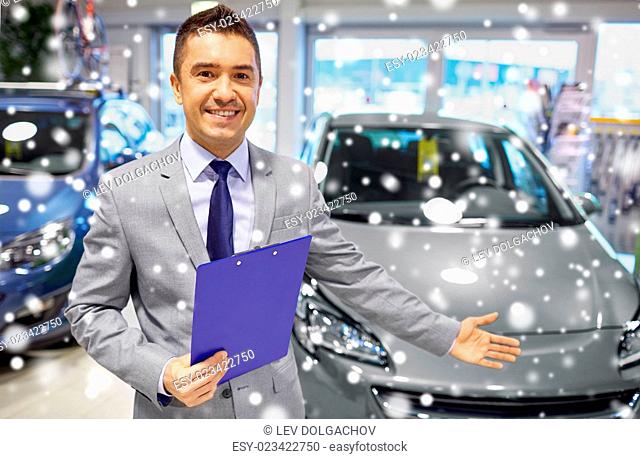 auto business, car sale, consumerism and people concept - happy man with clipboard at auto show or salon over snow effect