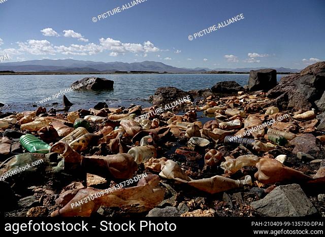 07 April 2021, Bolivia, Oruro: Orange plastic bottles lie on Lake Uru Uru. According to the Oruro government's environmental agency