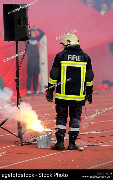 Firefighter putting down football fans' torches fire during a match between Bulgaria's CSKA and Levski