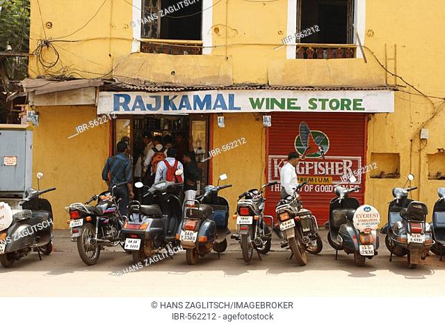 A row of men at a wine store in a street of Panaji or Panjim, Goa, India