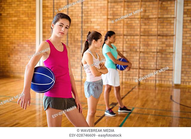 Portrait of high school kids standing with basketball