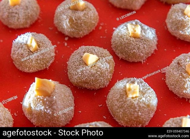 Homemade milk sweets called beijinho served on a red tray. Sweets for birthday party. Delicious desserts. Decorated kisses and served on a colorful plate