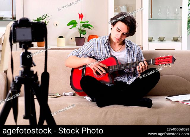 Young guitar player recording video for his blog