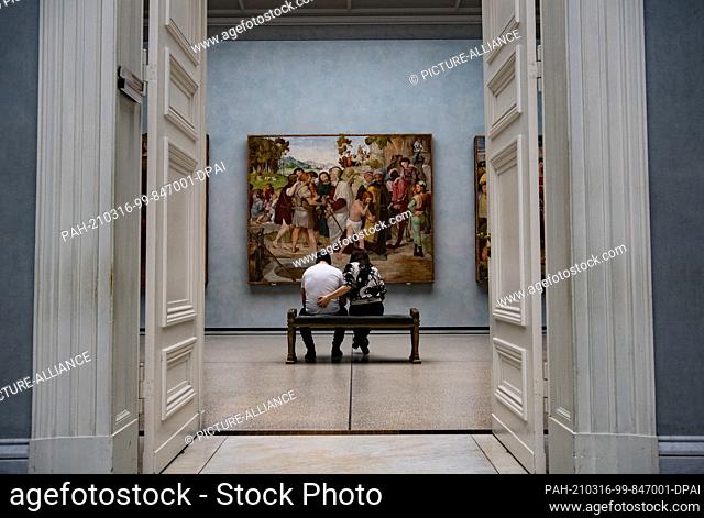 16 March 2021, Berlin: Two visitors sit in front of the painting by Friedrich Overbeck entitled ""Joseph is sold by his brothers"" in the Alte Nationalgalerie