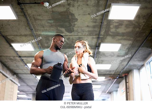 Trainer and female client talking in gym
