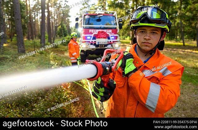 PRODUCTION - 09 August 2022, Lower Saxony, Wietzendorf: Volunteer firefighters practice the use of the forest fire tanker ""CCFM 3000""