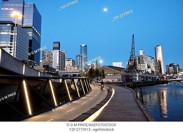 Cyclists on Jim Stynes Bridge, with Melbourne skyline