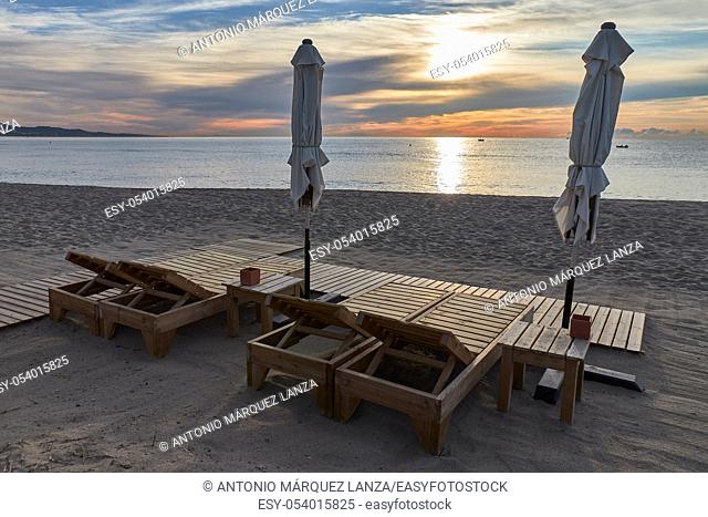 beach lounger at sunrise with parasol