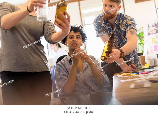 Creative designers examining bottles in office