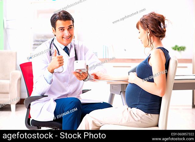 Young doctor checking pregnant woman's blood pressure