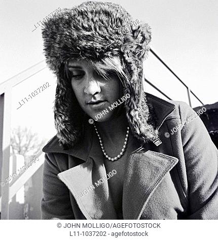 Woman in ushanka and coat, looking down