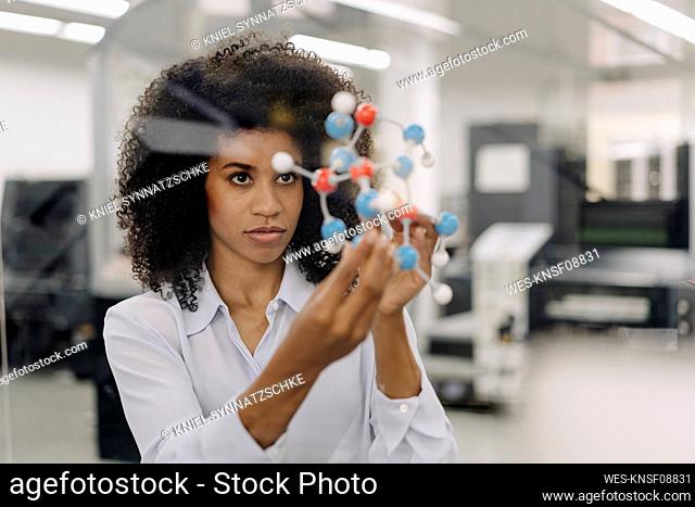 Female entrepreneur examining molecule in industry