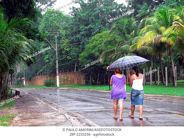 Two women walking in the rain at Mosqueiro Island near Belem northern Brazil