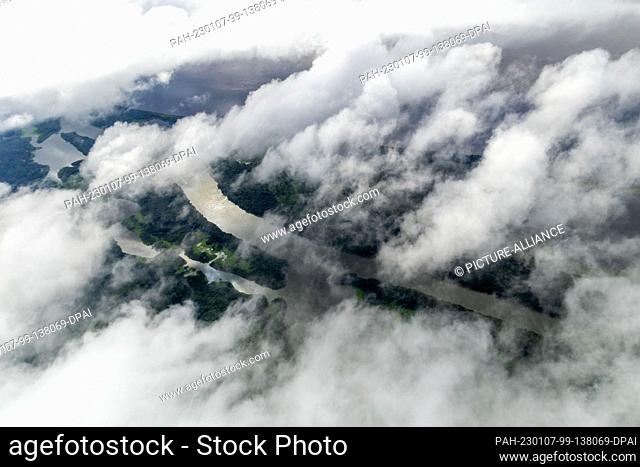 02 January 2023, Brazil, Manaus: Clouds pass over the Amazon rainforest, taken from a seaplane. The world's largest tropical rainforest is crisscrossed by...
