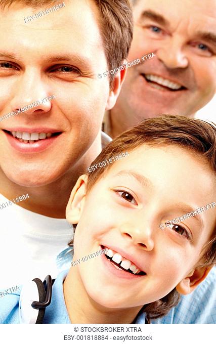 Close-up of a boyâ€™s face looking at camera among his father and grandfather