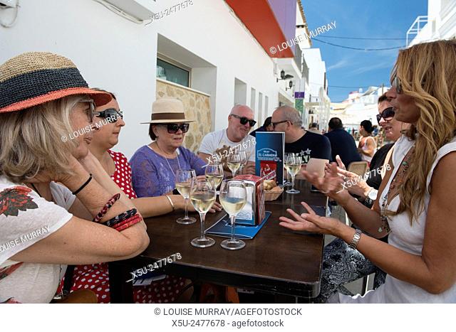 Friends enjoy tuna tapas and a glass of manzanilla sherry during the tuna festival in Zahara de los Atunes, Andalucia, Spain