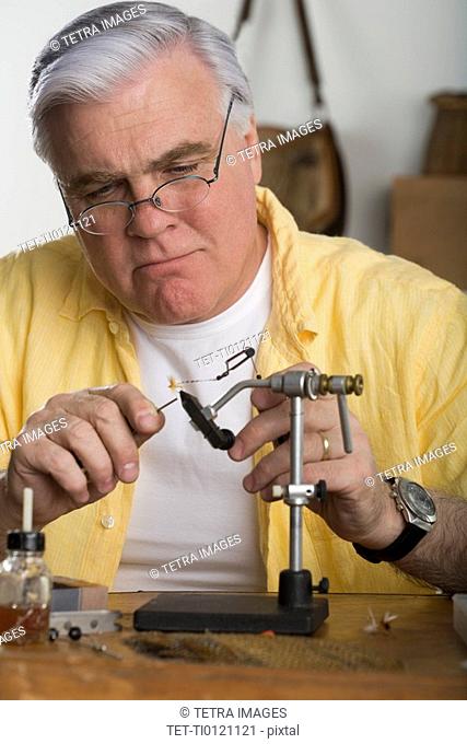 Senior man using soldering iron