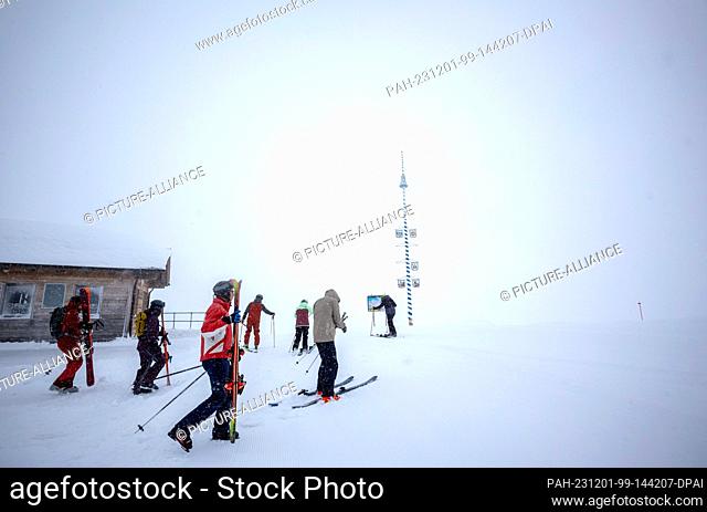 01 December 2023, Bavaria, Garmisch-Partenkirchen: Skiers set off for the opening of the ski season on the Zugspitze despite thick fog and snowfall