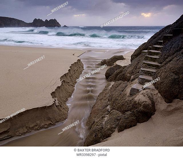 Stormy conditions on the beach looking out towards Logan Rock at Porthcurno, Cornwall, England, United Kingdom, Europe