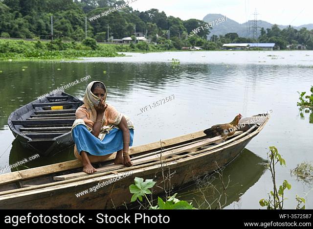 A woman siting on a boat in a flood effected village in Kamrup district of Assam, Monday, July 13, 2020