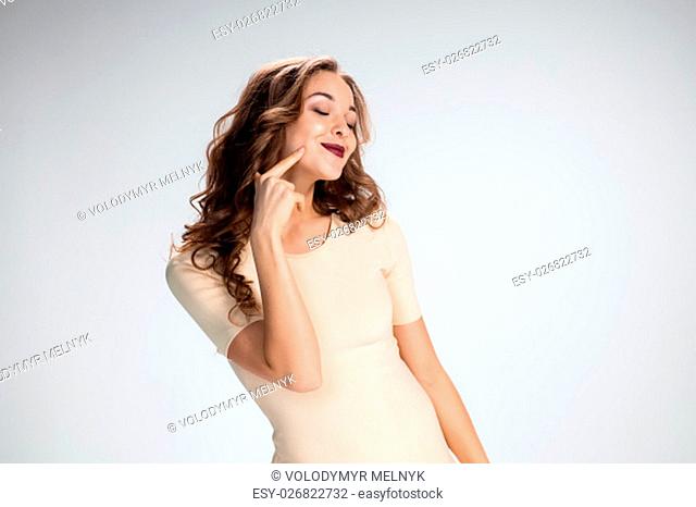 The young woman&#39;s portrait with love happy emotions on gray background