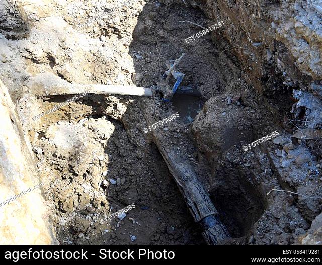 An excavated pit with a damaged pipeline. Repair of communications