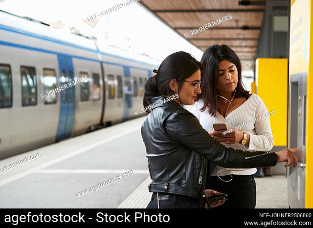 Woman using ticket machine at train station
