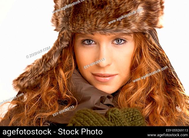 Attractive girl dressed up in coat, scarf and fur- hat