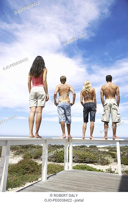 Two couples standing on the rail of a terrace