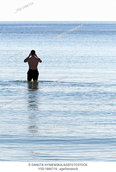 single man preparing for swimming in the sea, Mallorca, Balearic Islands, Spain, Europe