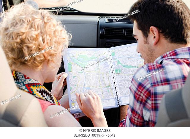 Couple examining map in jeep