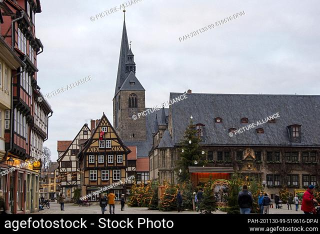 29 November 2020, Saxony-Anhalt, Quedlinburg: Christmas trees light up on the Quedlinburg market square. Normally a Christmas market is set up every year in...