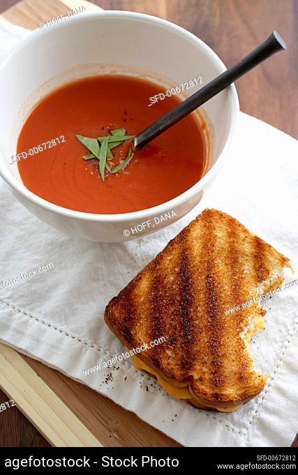 Partially Eaten Grilled Cheese Sandwich with a Bowl of Tomato Soup