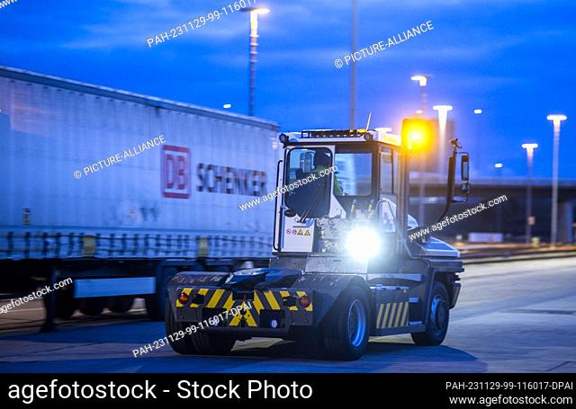 PRODUCTION - 21 November 2023, Mecklenburg-Western Pomerania, Rostock: A DB Schenker logistics company's tractor unit is on the move in the morning on the site...