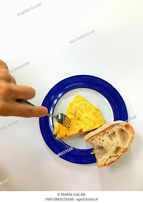 Hand taking a piece of Spanish omelet