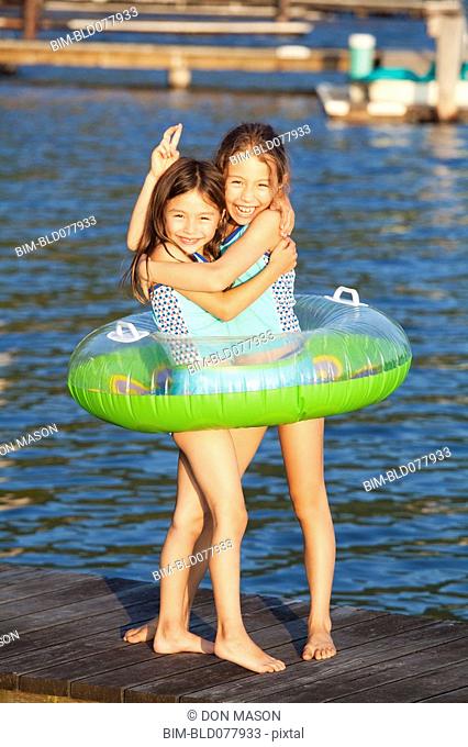 Mixed race sisters playing on pier