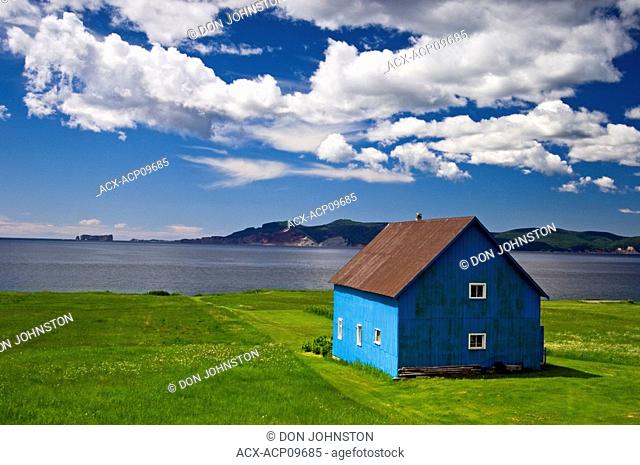 Blue barn overlooking Baie de Malbaieand distant Rocher Percé Rock, Gaspe Peninsula, Gaspe, Quebec, Canada