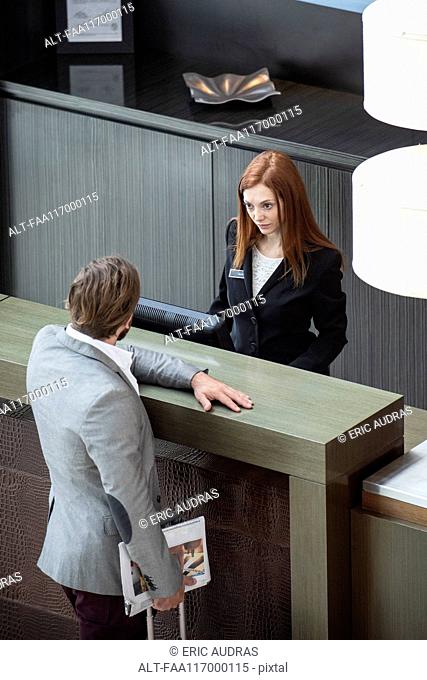 Businessman standing at hotel reception counter