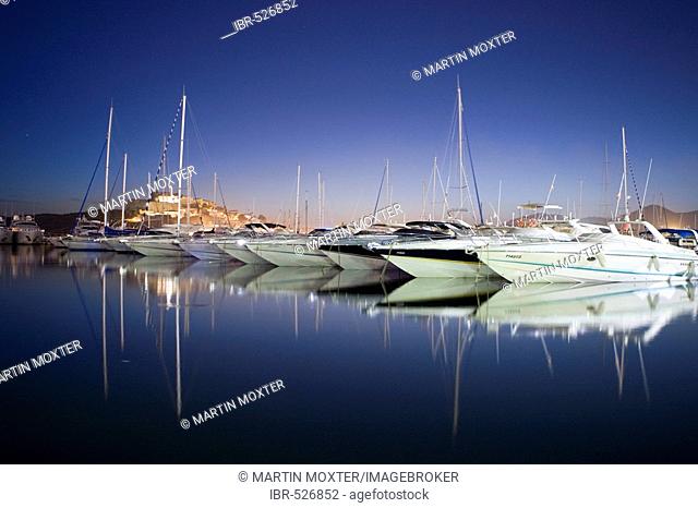Yachts in the marina of Eivissa in front of the Dalt Vila at dusk, Ibiza, Baleares, Spain