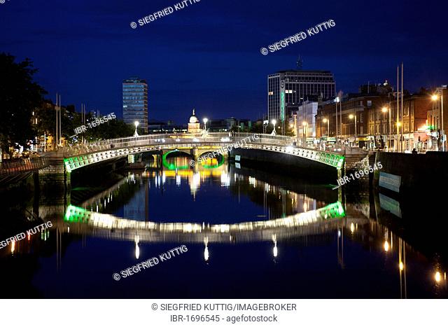 Illuminated Ha'penny Bridge in front of Liberty Hall, Custom House and O'Connell Bridge, Dublin, Republic of Ireland, Europe