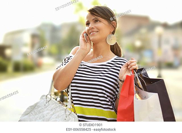 beautiful young woman with shopping bags, walking down the street