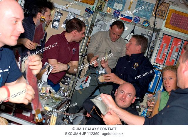 Eight of ten astronauts and cosmonauts currently sharing work on the International Space Station share a mealtime on the Zvezda service module