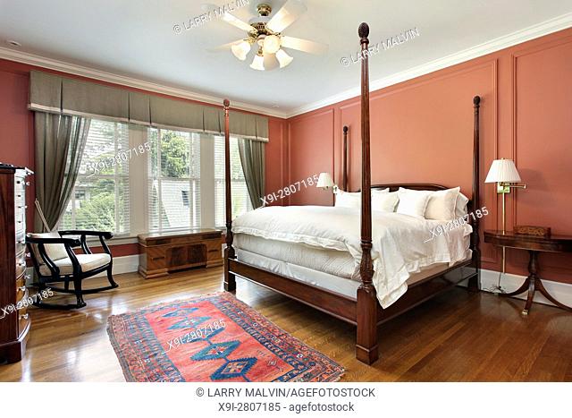 Master bedroom in luxury home with salmon colored walls. Northern Suburbs of Chicago, IL. USA
