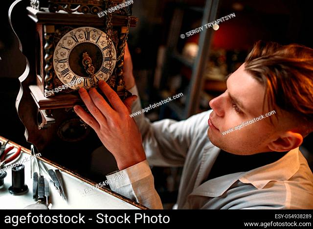 Watchmaker adjusts the mechanism of old watches in the workshop. Clock maker at work