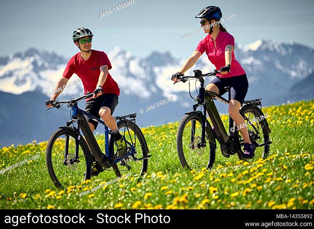 Young couple on eBikes, near Penzberg, voralpenland, Bavaria, Germany